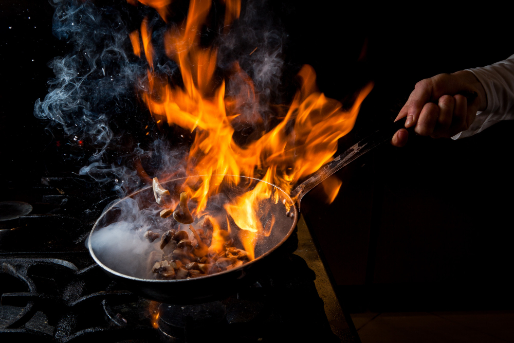 side view mushroom frying with stove fire human hand pan